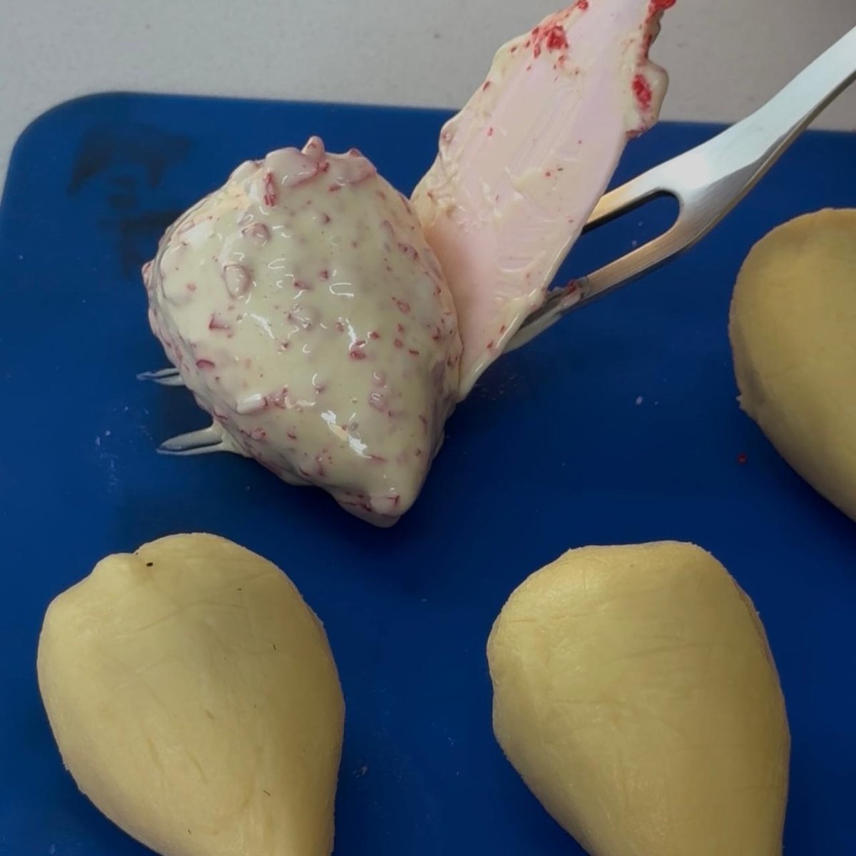 Coxinha banhada sendo apoiada no tapete de silicone